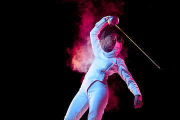 Image showing Teen girl in fencing costume with sword in hand isolated on black background