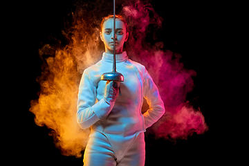 Image showing Teen girl in fencing costume with sword in hand isolated on black background