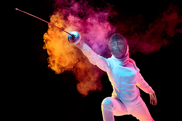 Image showing Teen girl in fencing costume with sword in hand isolated on black background