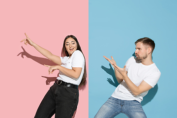 Image showing Young emotional man and woman on pink and blue background