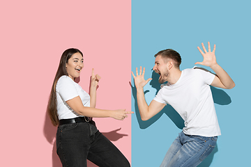 Image showing Young emotional man and woman on pink and blue background