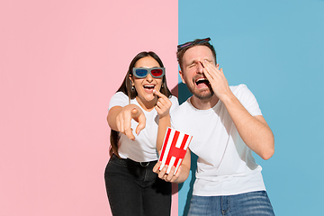 Image showing Young emotional man and woman on pink and blue background