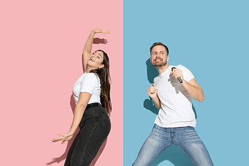 Image showing Young emotional man and woman on pink and blue background