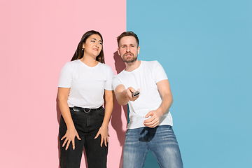 Image showing Young emotional man and woman on pink and blue background