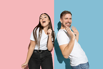 Image showing Young emotional man and woman on pink and blue background