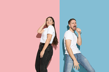 Image showing Young emotional man and woman on pink and blue background