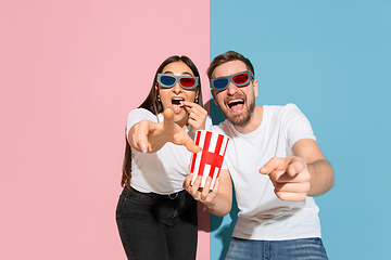 Image showing Young emotional man and woman on pink and blue background