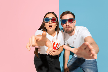 Image showing Young emotional man and woman on pink and blue background