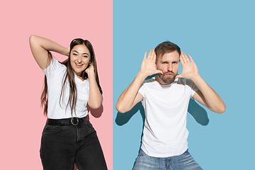 Image showing Young emotional man and woman on pink and blue background