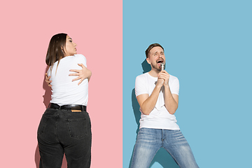 Image showing Young emotional man and woman on pink and blue background