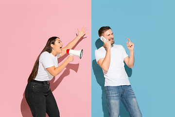 Image showing Young emotional man and woman on pink and blue background