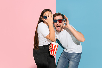 Image showing Young emotional man and woman on pink and blue background