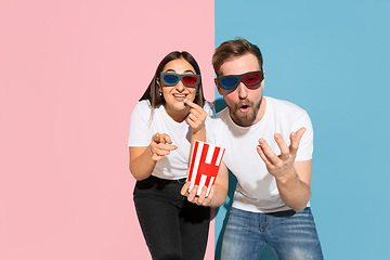 Image showing Young emotional man and woman on pink and blue background