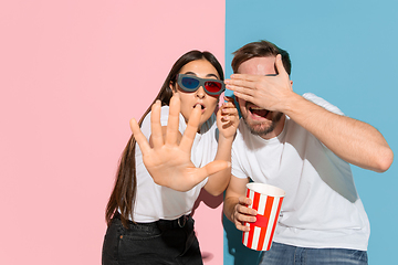 Image showing Young emotional man and woman on pink and blue background