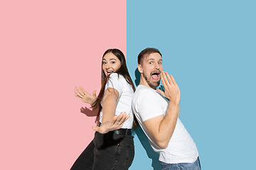 Image showing Young emotional man and woman on pink and blue background