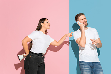 Image showing Young emotional man and woman on pink and blue background