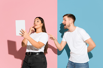 Image showing Young emotional man and woman on pink and blue background