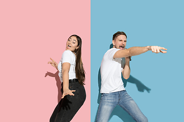 Image showing Young emotional man and woman on pink and blue background