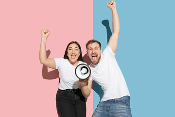 Image showing Young emotional man and woman on pink and blue background