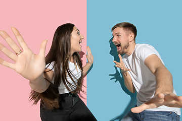 Image showing Young emotional man and woman on pink and blue background