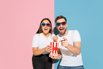 Image showing Young emotional man and woman on pink and blue background