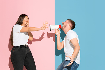 Image showing Young emotional man and woman on pink and blue background