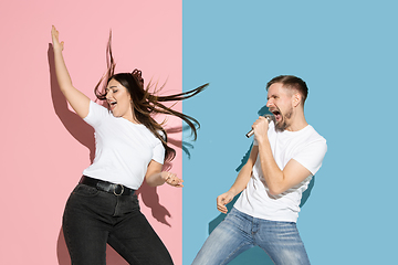 Image showing Young emotional man and woman on pink and blue background