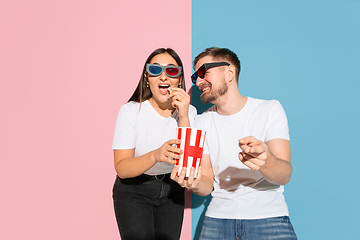 Image showing Young emotional man and woman on pink and blue background