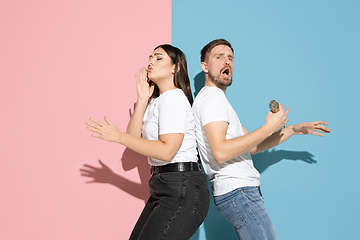 Image showing Young emotional man and woman on pink and blue background