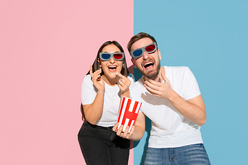 Image showing Young emotional man and woman on pink and blue background