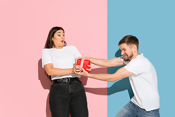 Image showing Young emotional man and woman on pink and blue background