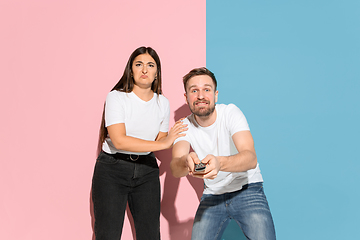 Image showing Young emotional man and woman on pink and blue background