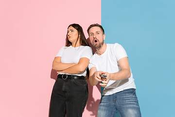 Image showing Young emotional man and woman on pink and blue background