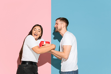 Image showing Young emotional man and woman on pink and blue background