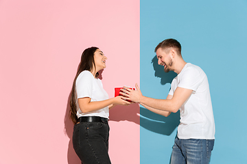 Image showing Young emotional man and woman on pink and blue background