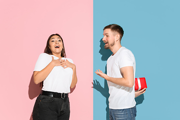 Image showing Young emotional man and woman on pink and blue background