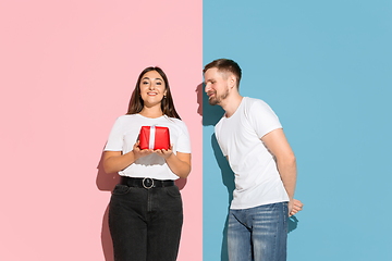 Image showing Young emotional man and woman on pink and blue background