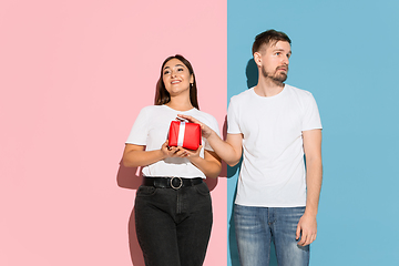 Image showing Young emotional man and woman on pink and blue background