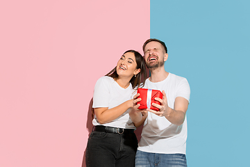 Image showing Young emotional man and woman on pink and blue background