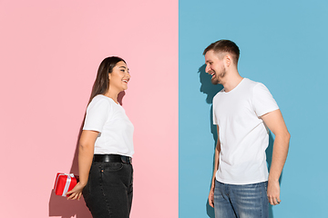 Image showing Young emotional man and woman on pink and blue background