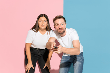 Image showing Young emotional man and woman on pink and blue background