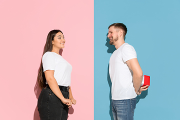 Image showing Young emotional man and woman on pink and blue background