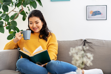 Image showing woman reading book and drinking coffee at home