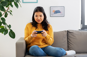 Image showing asian woman with gamepad playing game at home