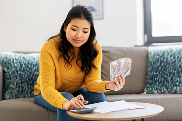 Image showing woman with money, papers and calculator at home