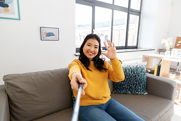 Image showing asian woman taking selfie and waving hand at home