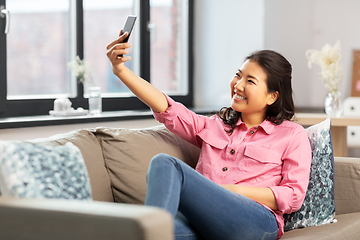 Image showing asian woman taking selfie with smartphone at home