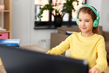 Image showing girl in headphones with laptop computer at home