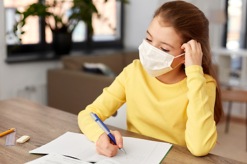 Image showing bored sick girl in medical mask learning at home