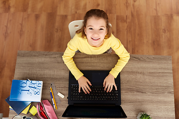 Image showing smiling student girl typing on laptop at home